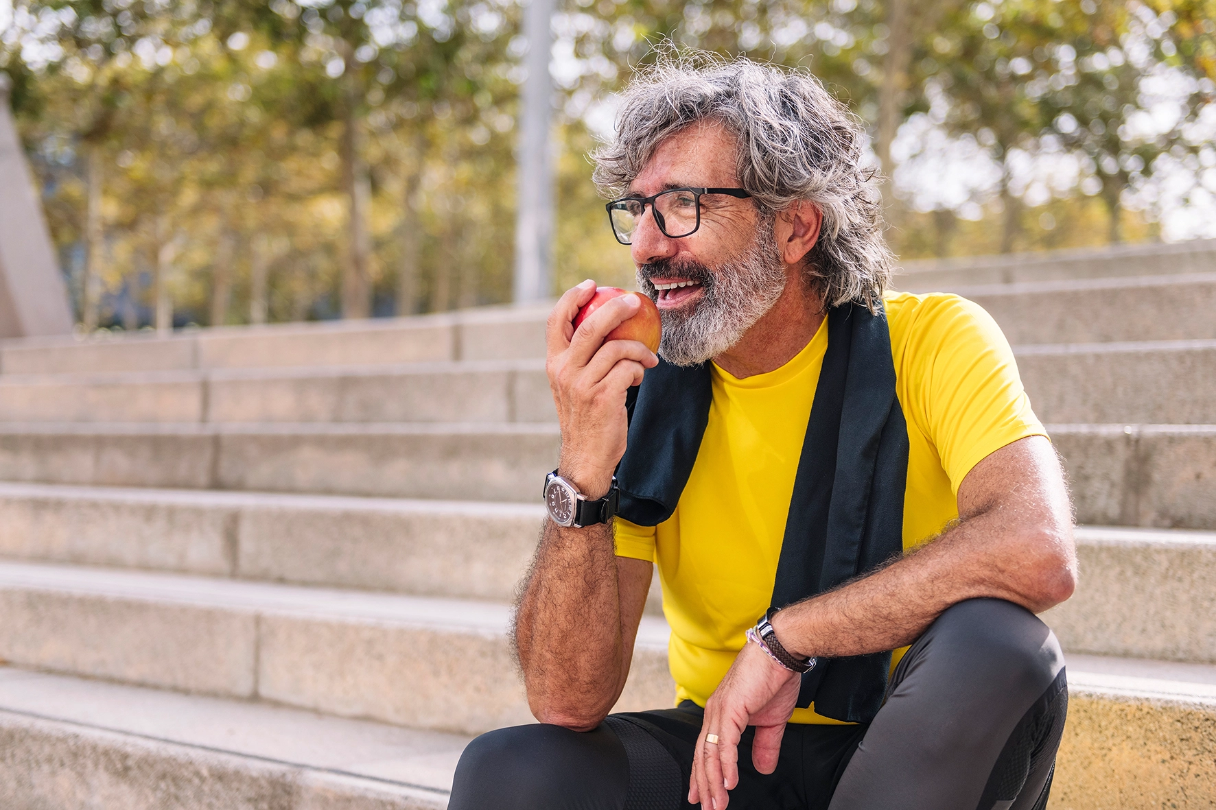 Mann nach dem Sport mit einem Apfel in der Hand – Symbol für gesunde Ernährung und aktiven Lebensstil